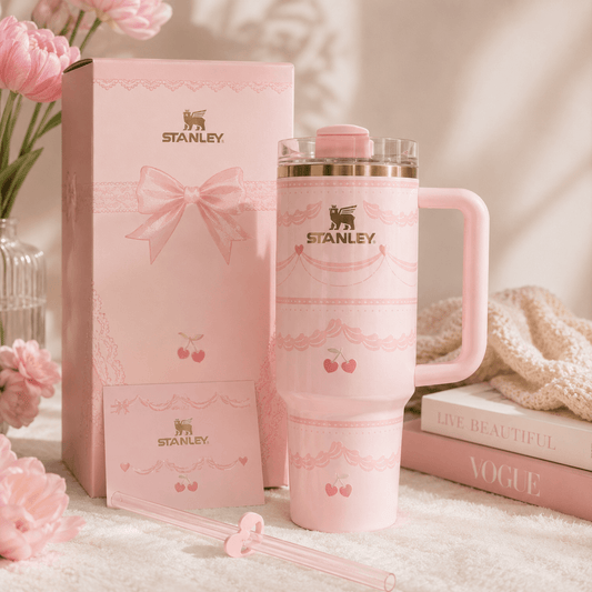 Pink Stanley mug and packaging with flowers and books in the background