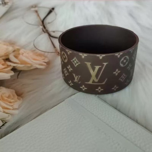 Brown container with a pattern on a white surface with flowers