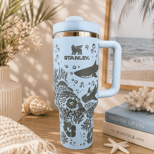 Stanley mug with ocean design on a table with books and decor