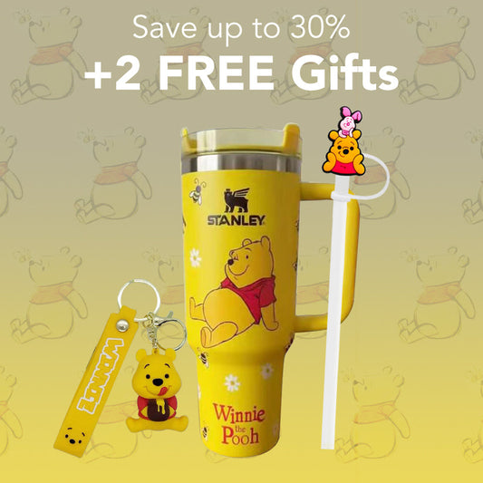 Yellow Stanley tumbler with Winnie the Pooh design, keychain, and straw on a yellow background with cartoon bears.