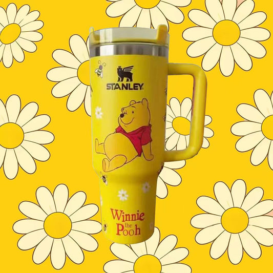 Yellow tumbler with Winnie the Pooh design on a yellow background with daisies