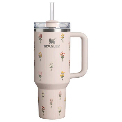 Stanley 40oz insulated tumbler featuring delicate wildflower illustrations, soft blush pink finish, white ergonomic handle, and insulated design